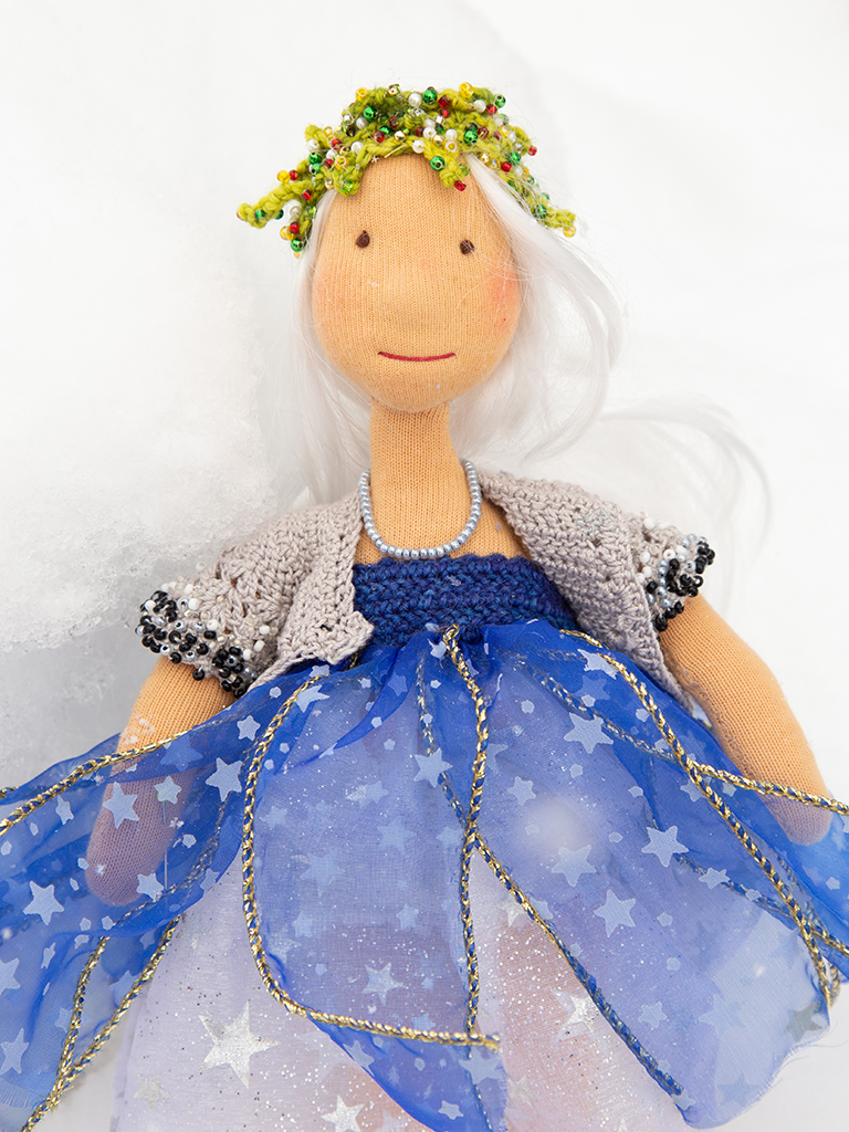 Lucia im Schneefall, den man leider nicht sieht, silbernes Kleid mit Sternchendrauf, blaue Bahnen über dem Silberkleid, ebenfalls mit silbernen Sternchen, gehäkelte Raglanweste, ärmellos, an den Armeln bestickt mit schwarzen, silbernen und weißen Perlen
