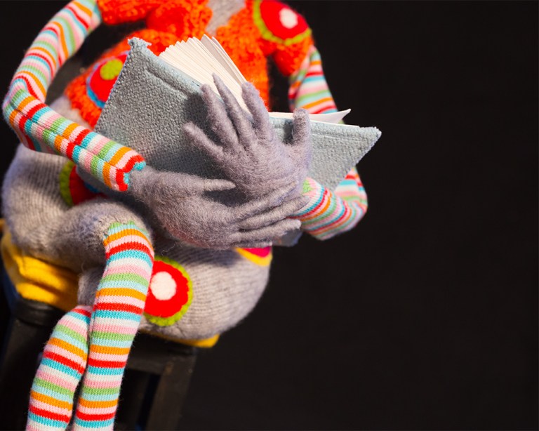 gefilzte Rattenhände halten ein Buch